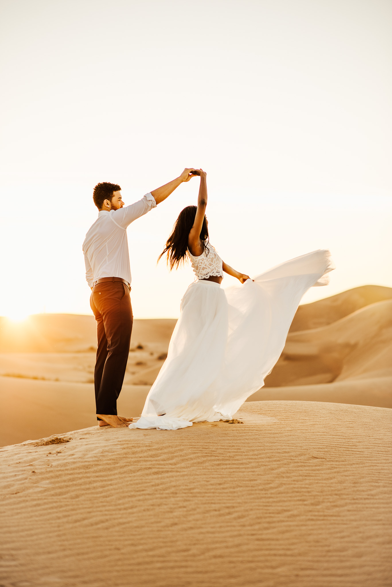 Bride and groom dancing at the sand dunes