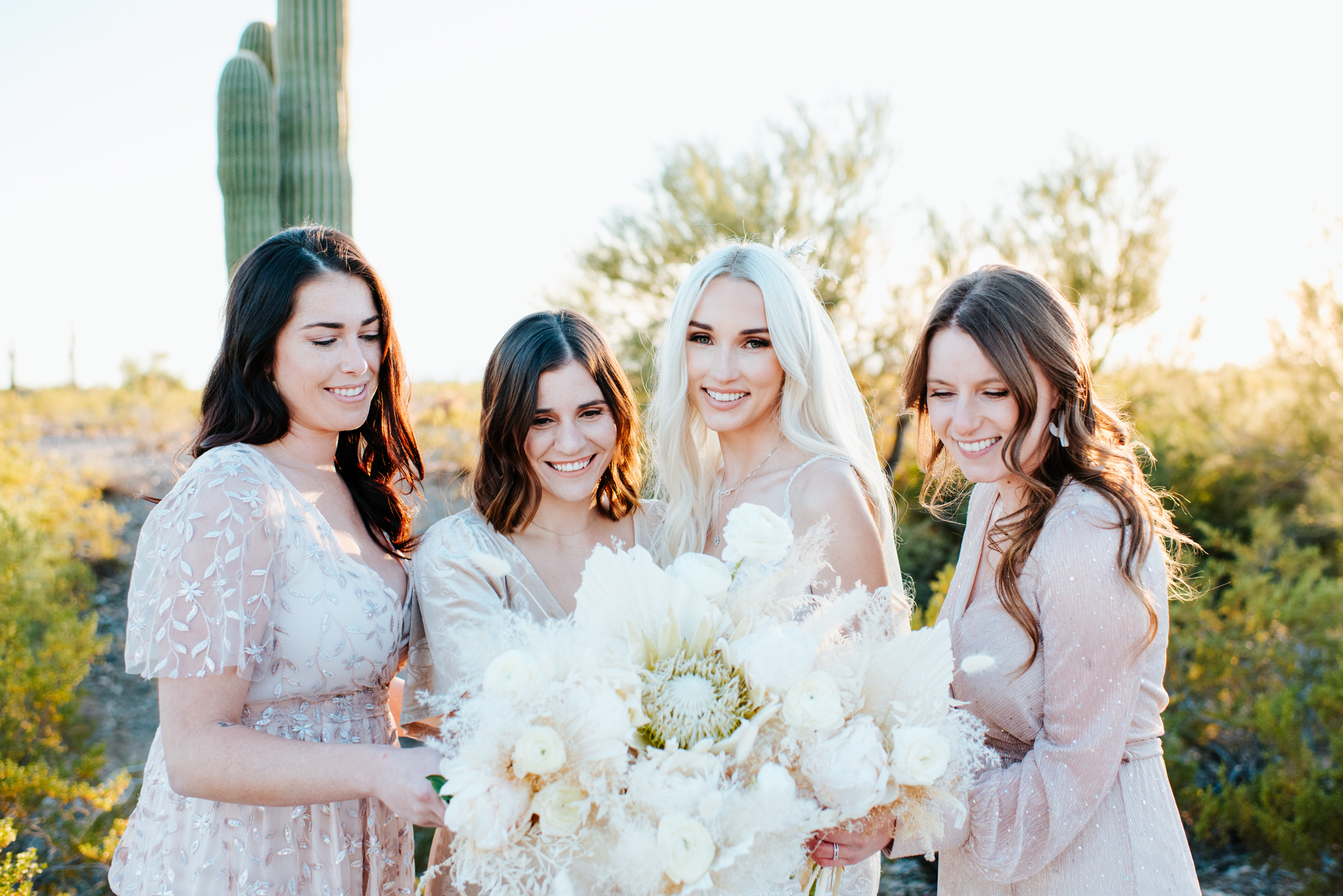 A bride and her bridesmaids at the El Chorro wedding venue in Phoenix, standing together and smiling.